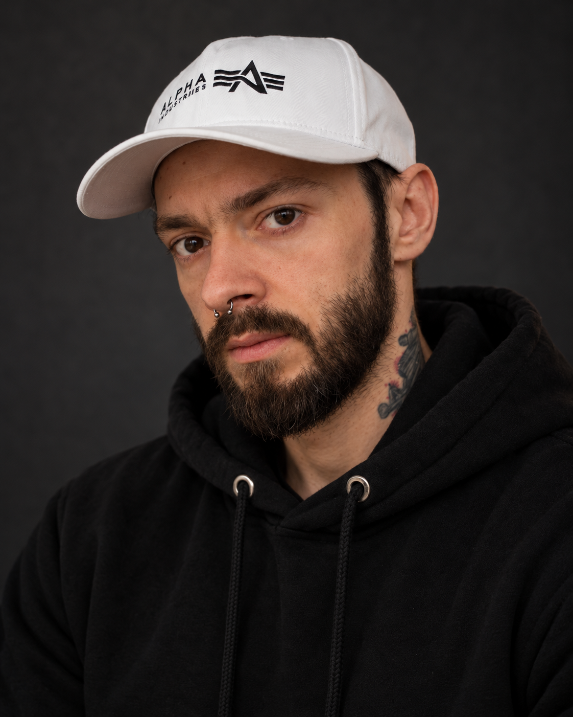 Porträt von Crazy_Batto mit weißer Kappe und schwarzem Hoodie